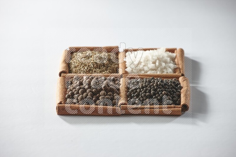 4 squares of cinnamon sticks full of cumin, white salt, allspice and black pepper on white flooring