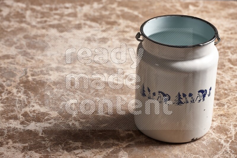 A vintage milk can on beige marble background
