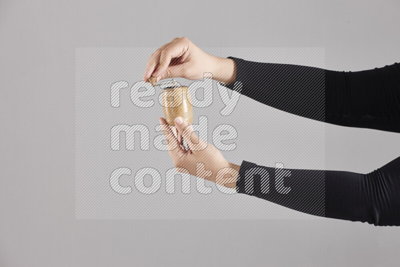 A woman in black abaya holding different wooden essentials in different positions