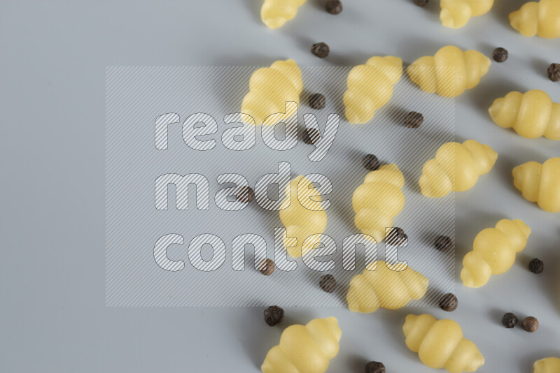 معكرونة مع مكونات متنوعة من الطماطم والثوم والبصل والفلفل الأحمر والفلفل الأسود والفلفل الأبيض وأوراق الغار وإكليل الجبل والهيل و مشروم على خلفية زرقاء فاتحة