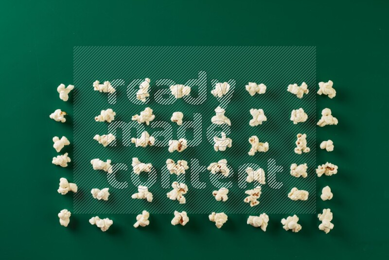 Popcorn flakes on a green background in a top view shot
