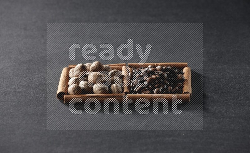 2 squares of cinnamon sticks full of coffee beans and nutmeg on black flooring
