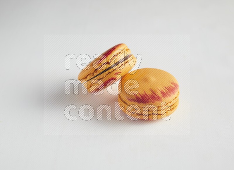 45º Shot of two orange Exotic macarons on white background