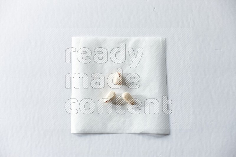 3 pistachios on a piece of paper on a white background in different angles