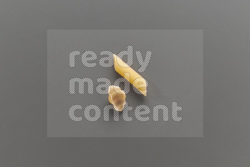 Snails pasta with other types of pasta on grey background