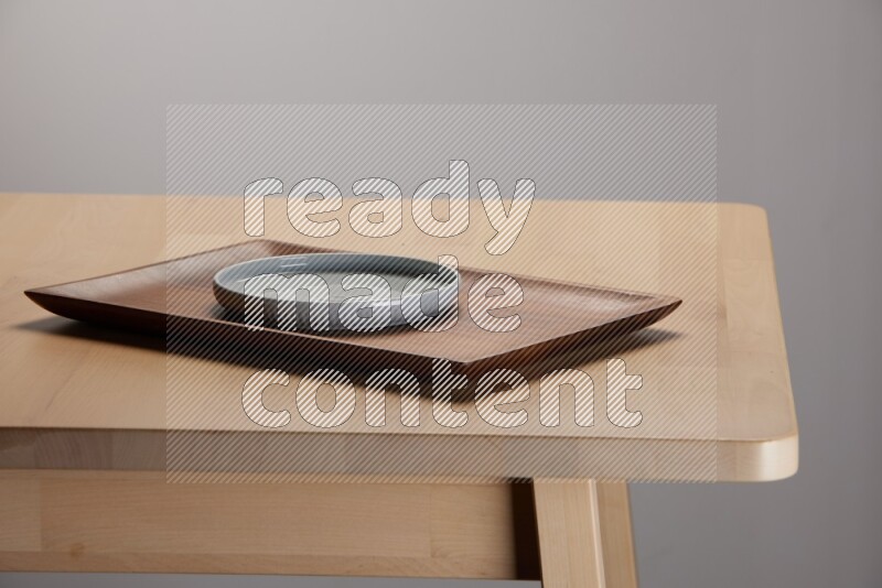 light blue plate placed on a wooden tray with  on the edge of wooden table