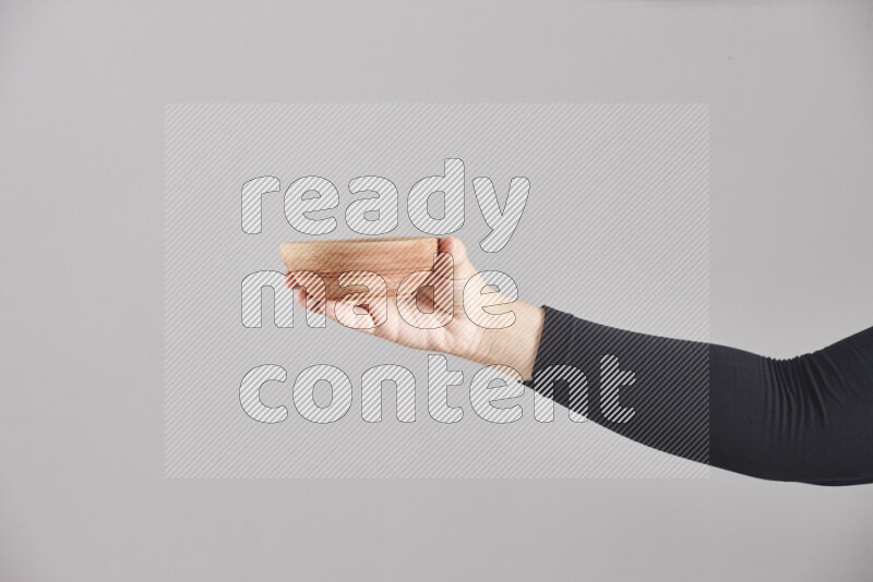 A woman in black abaya holding different wooden essentials in different positions