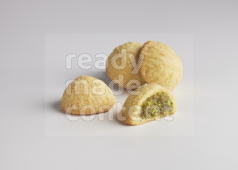 Four Pieces of Maamoul filled with pistachio  paste one of them is cut direct on white background