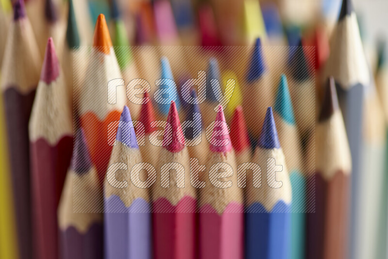 The image captures a close-up of sharpened colored pencils on multicolored background
