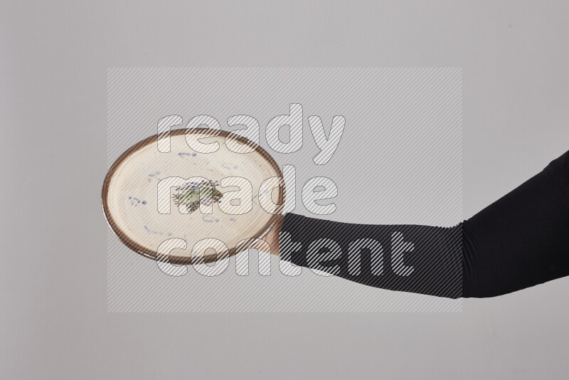 A woman in black abaya holding different pottery essentials in different positions