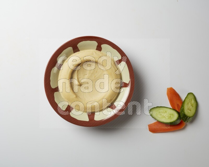 Plain hummus in a traditional plate on a white background