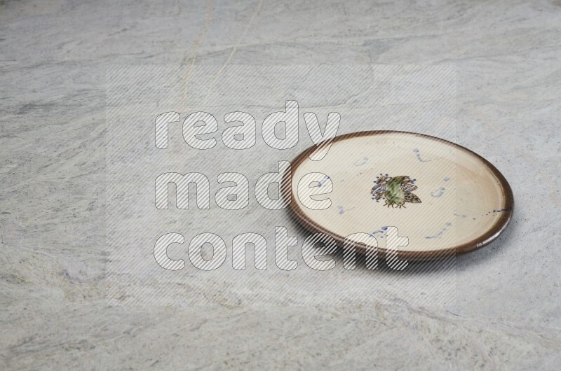A decorative pottery plate on grey marble background