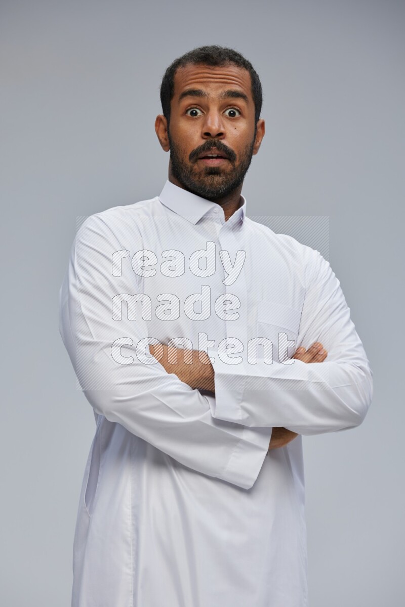 Saudi man wearing Thob standing with crossed arms on Gray background