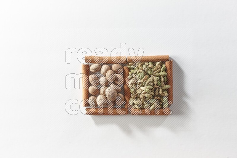 2 squares of cinnamon sticks full of cardamom and nutmegs on white flooring