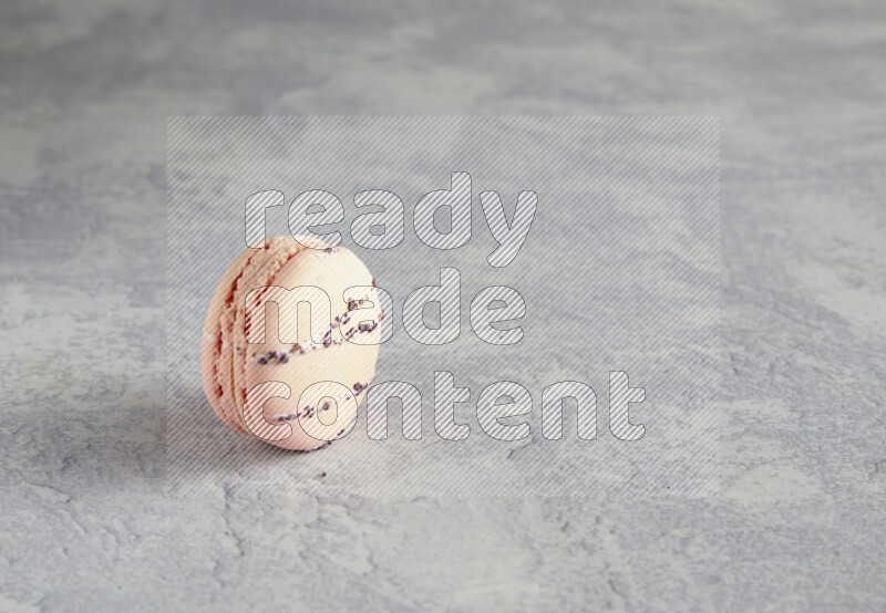 45º Shot of pink orange blossom macaron on white  marble background