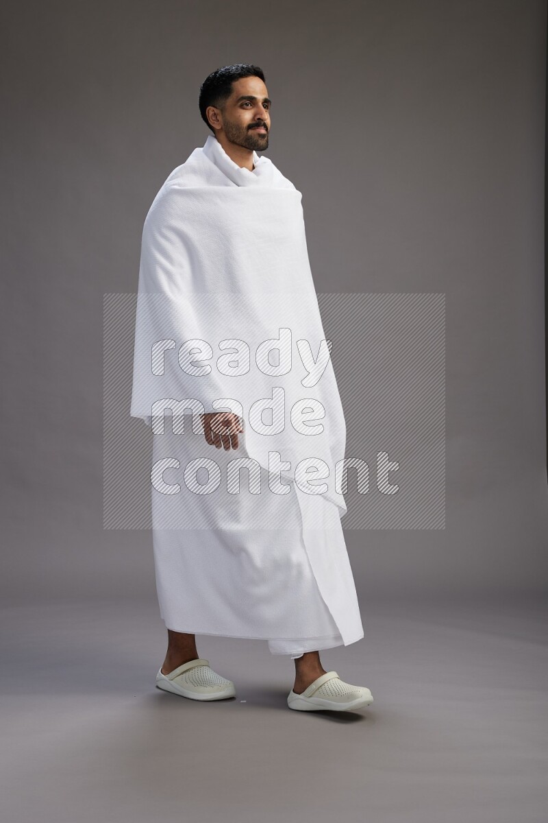 A man wearing Ehram Standing Interacting with the camera on gray background