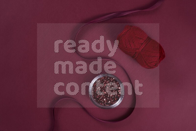 A red collection of sewing and tailoring tools arranged on a red background