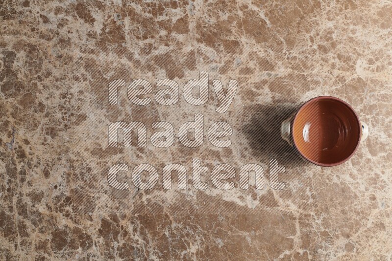 A multicolored pottery pot on beige marble background