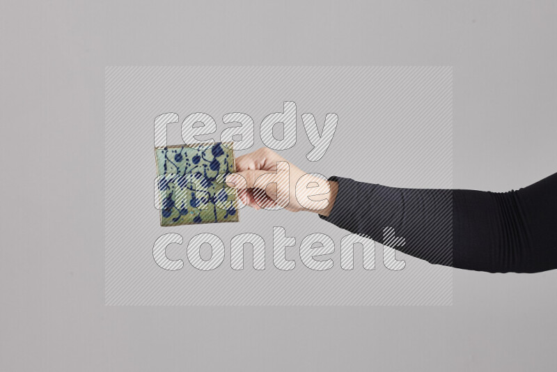 A woman in black abaya holding different pottery essentials in different positions