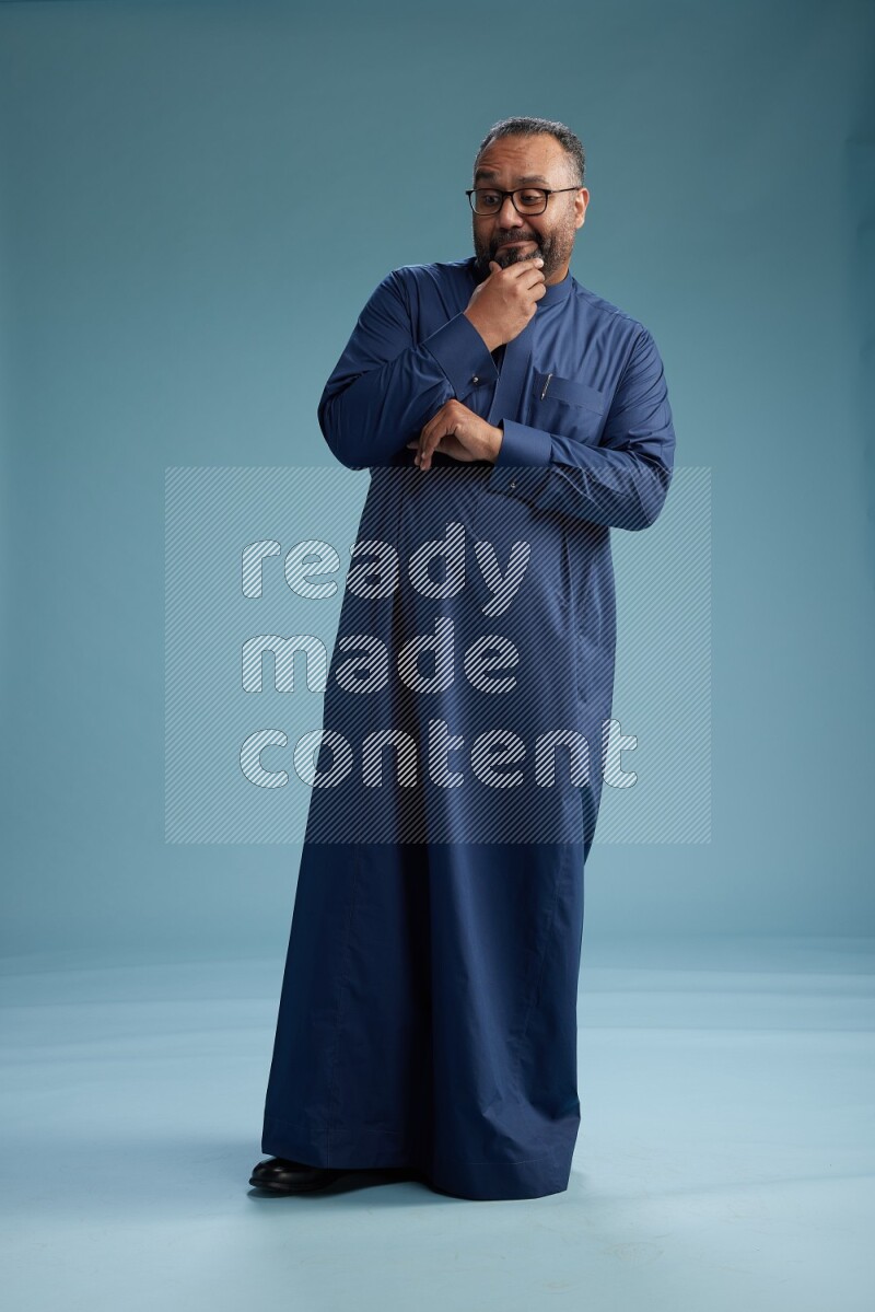 Saudi Man without shimag Standing Interacting with the camera on blue background