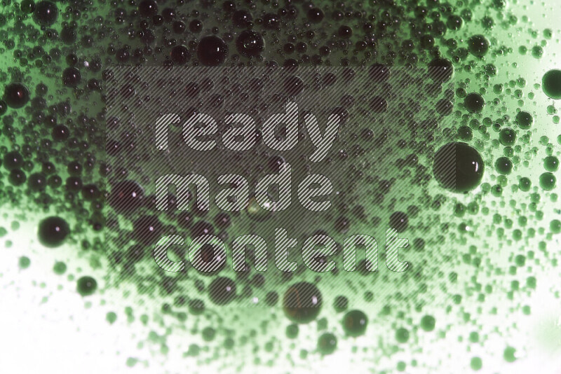 لقطات مقربة لقطرات ألوان مائية خضراء على سطح الزيت على خلفية بيضاء