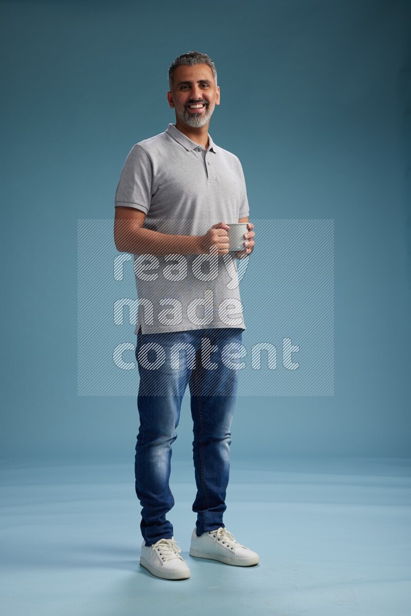 Man Standing drinking coffee on blue background