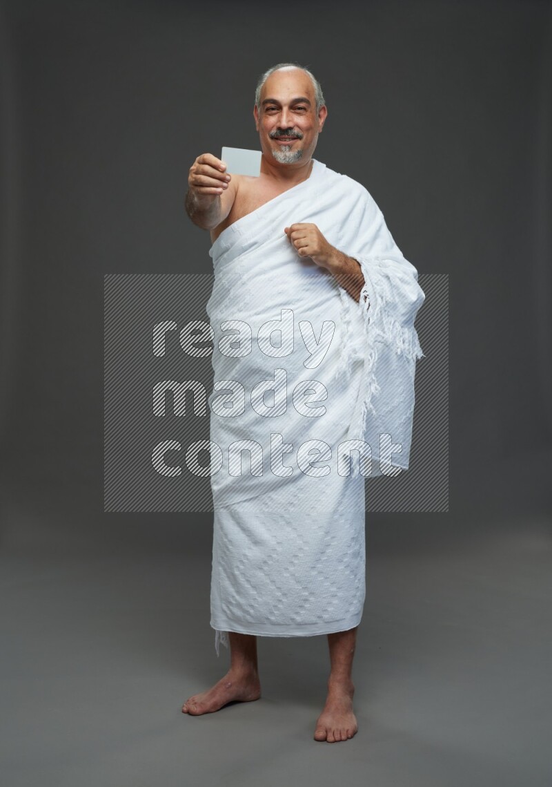 A man wearing Ehram Standing holding ATM card on gray background