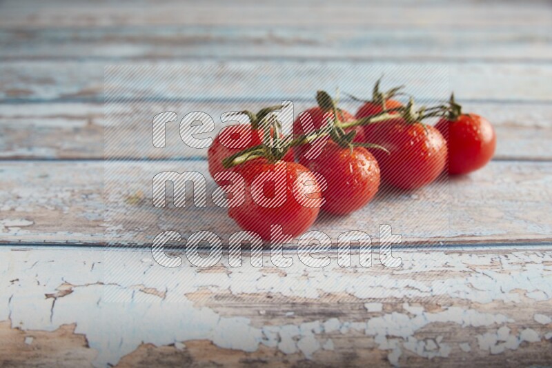 Red cherry tomato vein on a textured blue wooden background 45 degree