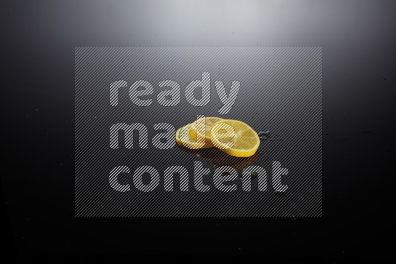 Lemon slices with water drops, and droplets on black background