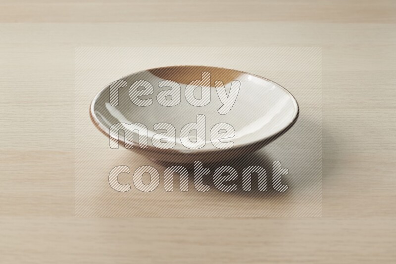 A multicolored pottery plate on light wooden background
