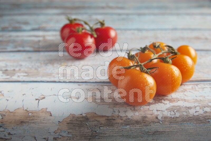 Mixed cherry tomato veins on a textured light blue wooden background 45 degree