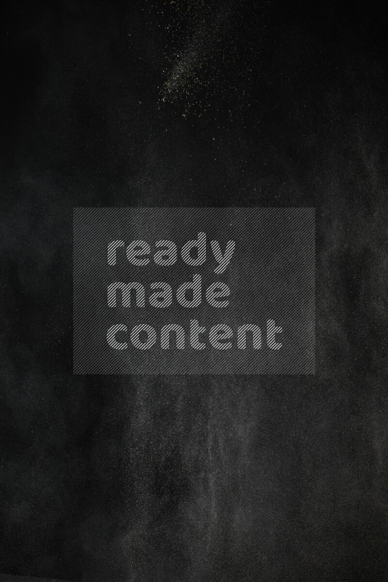 A side view of brown powder explosion on black background