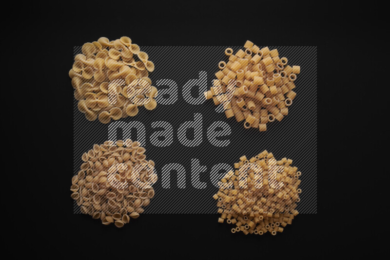 Different pasta types in bunches on black background