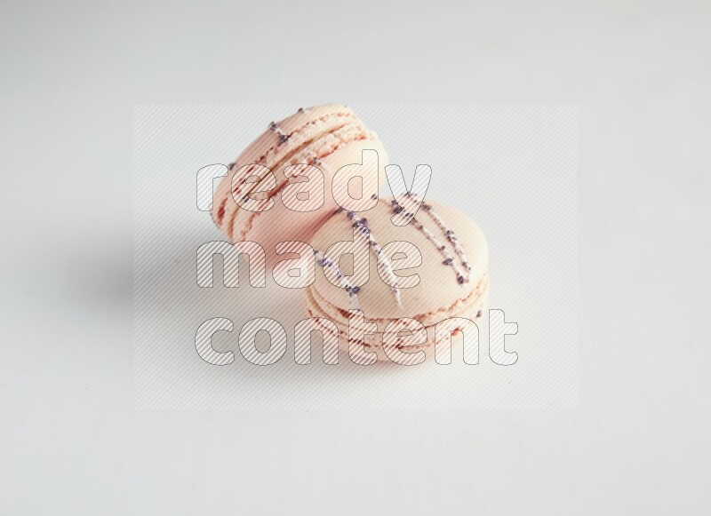 45º Shot of two pink orange blossom macarons on white background