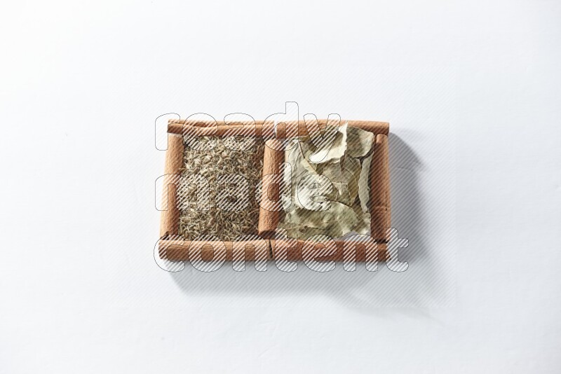 2 squares of cinnamon sticks full of bay laurel leaves and cumin on white flooring