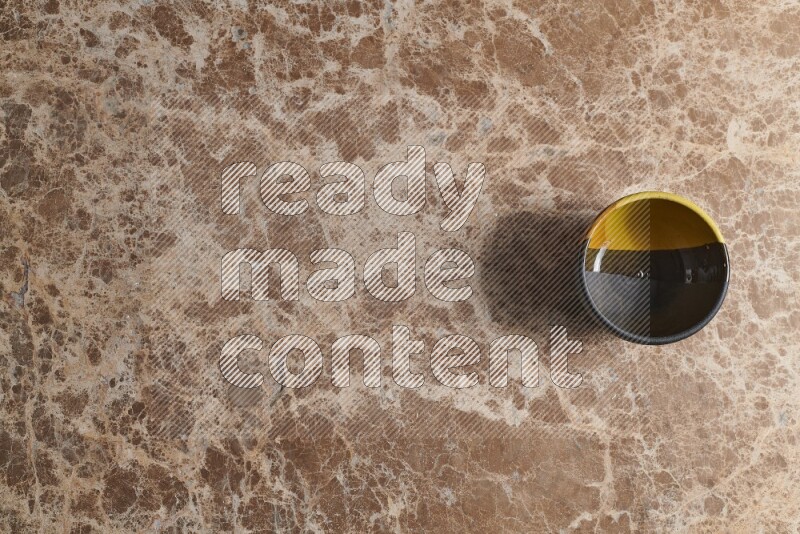 A multicolored pottery bowl on beige marble background