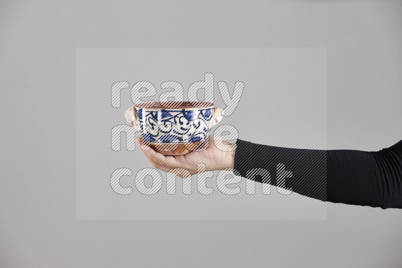 A woman in black abaya holding different pottery essentials in different positions