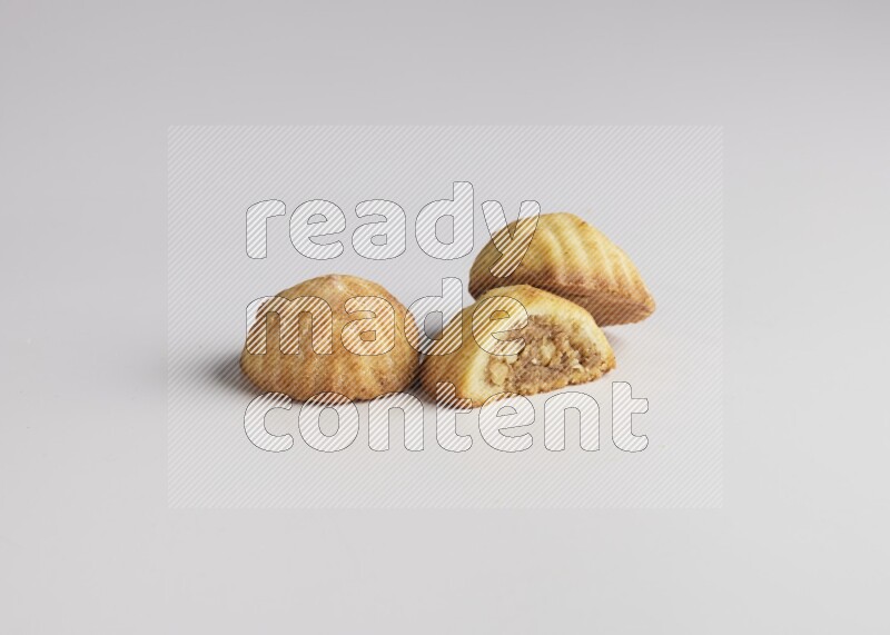 Three Pieces of Maamoul filled with walnut paste  one of them is cut direct on white background