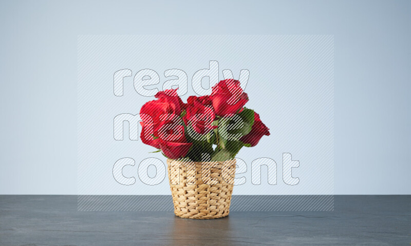 Vibrant red roses in a wicker basket on black marble background