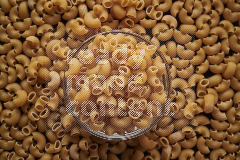 معكرونة هلالية في وعاء زجاجي علي خلفية سوداء