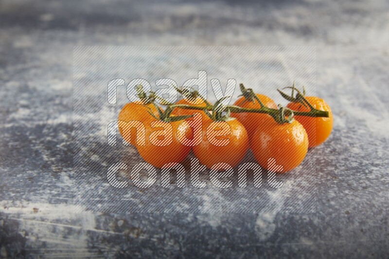 Orange cherry tomato vein on a textured rusty blue background 45 degree