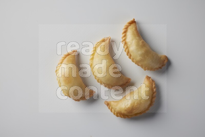 Four fried sambosa from a top angle on a white background