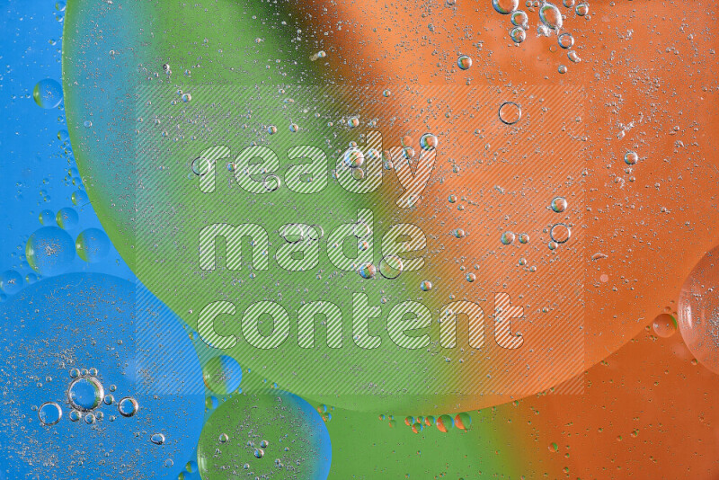 Close-ups of abstract oil bubbles on water surface in shades of orange, green and blue