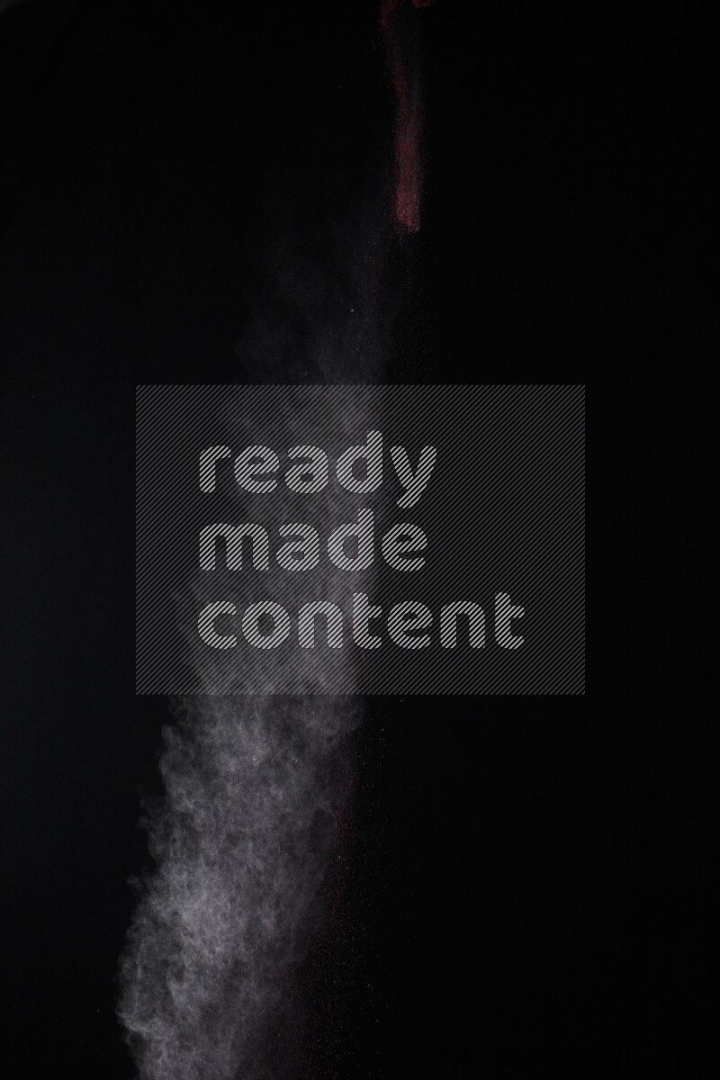 A side view of red powder explosion on black background