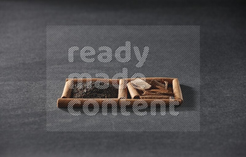 2 squares of cinnamon sticks full of tea and cinnamon on black flooring