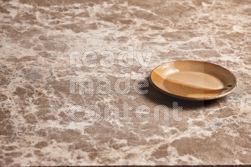 A multicolored pottery plate on beige marble background