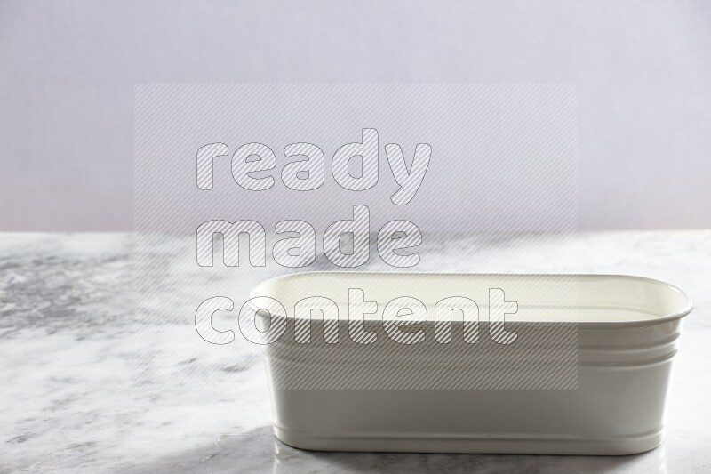 An empty white plant pot on grey marble background