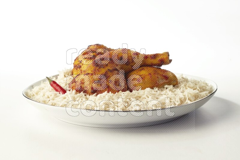 white basmati Rice with kabsa chicken pieces on a white plate with a silver rim direct on white background