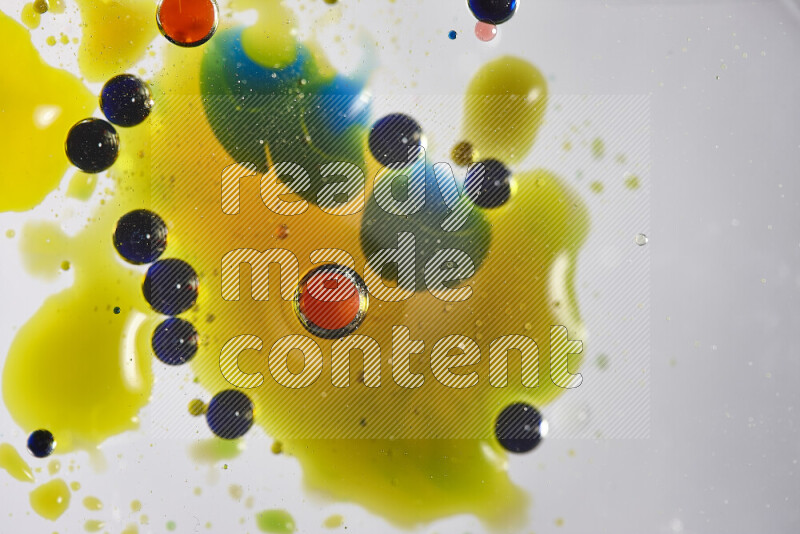 Close-ups of abstract red, blue, yellow and green watercolor drops on oil Surface on white background