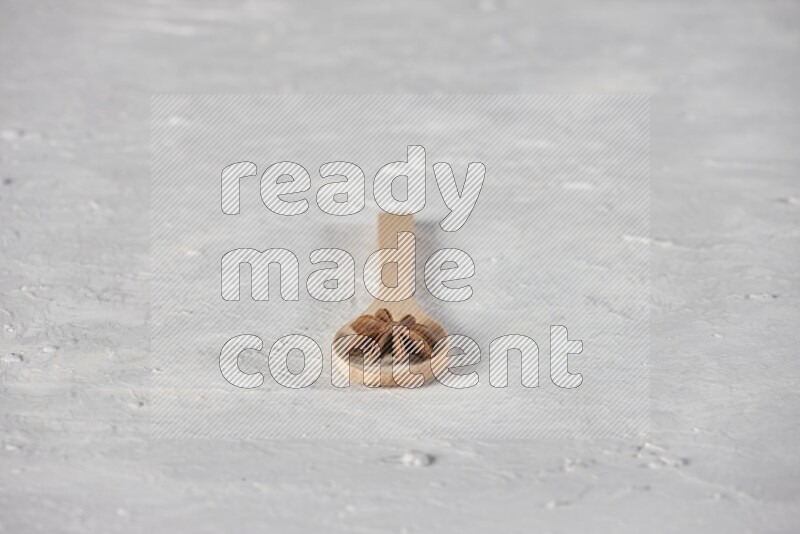 Star Anise in a wooden spoon on white flooring